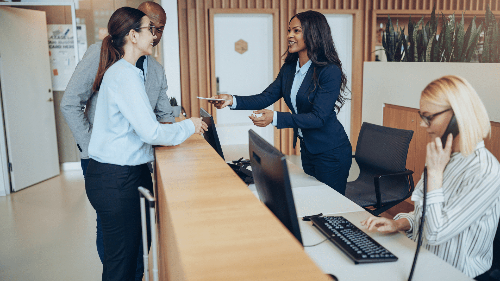 Diverse group of hotel guests communicating with staff
